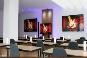 Habitación con mesas, sillas y pinturas en la pared. en TRYP by Wyndham Cuenca Zahir, en Cuenca