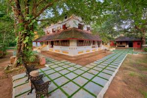 a large building with a tree in front of it at Seclude Karthika Nivas, Thrissur in Trichūr