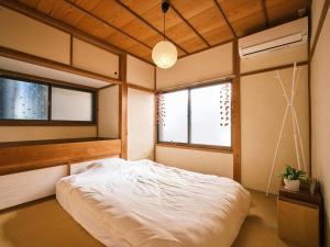 a bedroom with a white bed and two windows at 湊庵 赤橙 -so-an sekitou- in Inatori