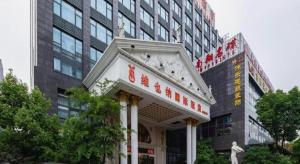 un edificio con una señal frente a un edificio en Vienna International Shanghai Nanxiang, en Chenjiahang