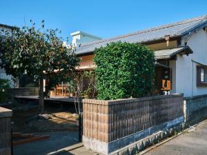 a house with a fence and a tree in front of it at 湊庵 赤橙 -so-an sekitou- in Inatori