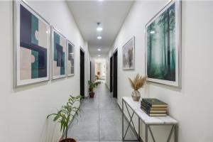 ein Flur mit Gemälden an den Wänden und Pflanzen in der Unterkunft Via HC Dream Majestic in Mohali