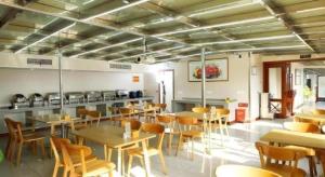 Un restaurante con mesas y sillas en una sala. en GreenTree Inn Wuxi Xinwu District Meicun Town Taibo Avenue, en Xuedian