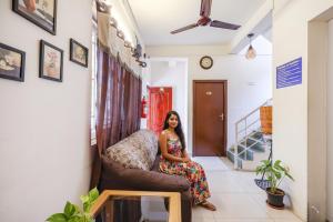 una mujer sentada en una silla en una habitación en Fabhotel Tristar Residency - Nr Tambaram Railway Station, en Chennai