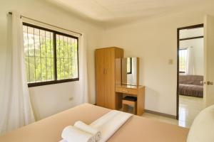 una camera bianca con un letto e asciugamani di Yayay Siargao a General Luna Altre 80 foto