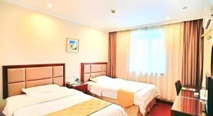 a hotel room with two beds and a window at GreenTree Inn Jinan Bus Terminal in Jinan +190 photos