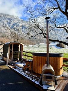 a wood stove sitting in front of a fence at Glarner Spa I Private Sauna & Hot Tub & Alps View in Ennenda