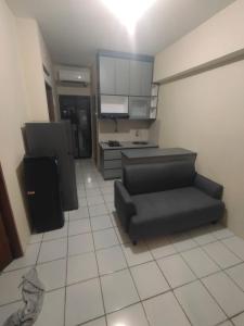 a living room with a couch and a kitchen at Aparta Homestay in Pekayon Satu