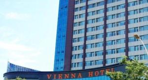 um prédio alto com uma placa na frente em Vienna Hotel Qingdao Jiaozhou Branch em Jiaoxian