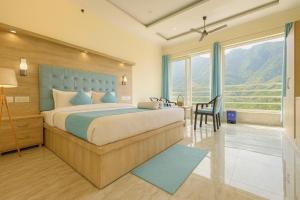 a bedroom with a bed and a desk with a chair at Sitara Hotel & Resort in the lap of nature, Mussoorie in Mussoorie