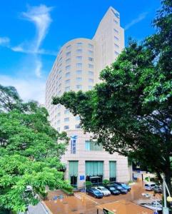 a tall building with cars parked in a parking lot at Xiamen Airlines Quanzhou Hotel in Quanzhou