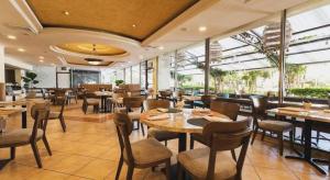um restaurante com mesas, cadeiras e janelas em Hotel Honduras Maya em Tegucigalpa