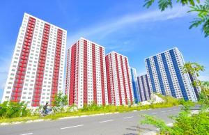 a row of tall red and white buildings next to a road at Dhonveli in Male City