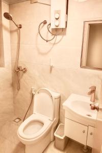 a small bathroom with a toilet and a sink at Dhonveli in Male City