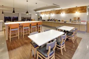 a restaurant with tables and chairs and a kitchen at La Quinta by Wyndham Dallas Love Field in Dallas