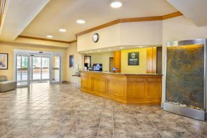 a hotel lobby with a cash register and a waiting area at Clarion Pointe in Rimbey +87 photos