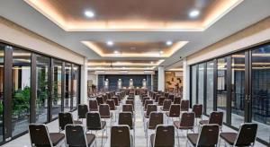 梳邦再也Lotus Hotel Subang的大型客房设有桌椅和窗户。