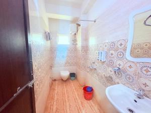 a bathroom with a sink and a toilet at ফোর স্কয়ার Four Square Lite Heaven Digha Near The Sea Beach in Digha +39 photos