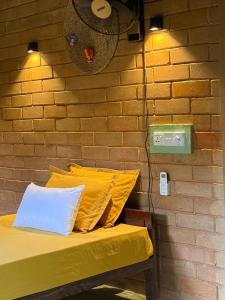 een bank met twee kussens en een bakstenen muur bij Eco Bricks in Ahangama
