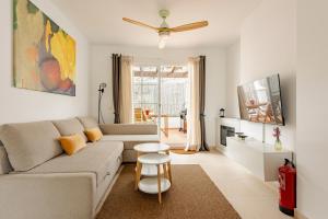 un soggiorno con un divano e un tavolo di Wonder Atic, with private terraces, jacuzzi and stunning views a Cómpeta