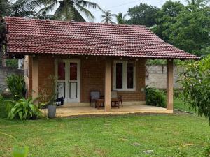 a small brick house with a red roof at Eco Bricks in Ahangama