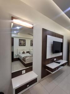 a hotel room with a bed and a mirror at Hotel The Sankalp Retreat in Bhavnagar +15 photos