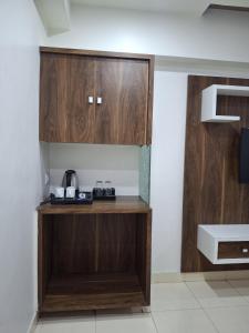 a kitchen with wooden cabinets and a coffee maker at Hotel The Sankalp Retreat in Bhavnagar