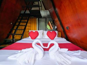ein Bett mit zwei Schwänen in Herzform in der Unterkunft Fern Hollow in Ella