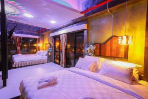 een slaapkamer met 2 bedden en een kroonluchter bij Ps Extra Hotel in Ban Kohong