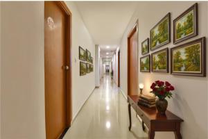 a corridor of a hospital with a hallway with paintings on the walls at FabHotel Green Park in Ahmedabad