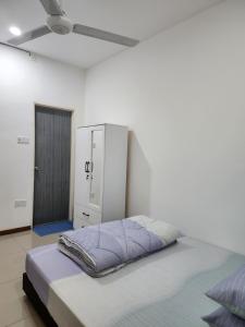 Warisan Iman Inn في كلانغ: غرفة نوم بيضاء مع سرير وخزانة