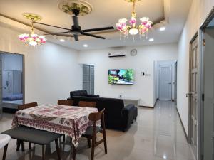 Warisan Iman Inn في كلانغ: غرفة معيشة بها طاولة وأريكة +12 صورة