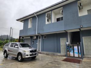 Warisan Iman Inn في كلانغ: سيارة رياضية فضية متوقفة أمام مبنى أزرق