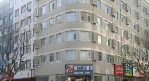 a tall building with a sign in front of it at Jinjiang Inn Qingdao Development Zone Jinggangshan Rd. in Huangdao