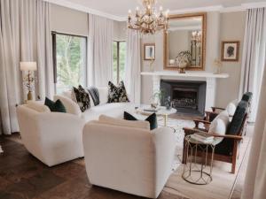 a living room with white furniture and a fireplace at The First House Luxury Villa, Eden Rock Estate in Pennington