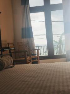 a bedroom with a bed and a large window at Raaju fisherman life resort in Walliwala East