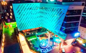 an overhead view of a large blue building at night at LiT BANGKOK Hotel - SHA Extra Plus in Bangkok