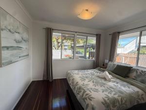 Un dormitorio con una cama y una ventana grande. en Chic Urban Escape in Norman Park, en Brisbane