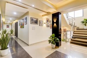 a hallway with potted plants and stairs at Via Sun n Shine in Pune