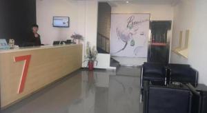 a woman standing at a counter in a salon at 7 Days Premium·Zaozhuang High-speed Railway Station Guangming Xi Road in Taozhuang