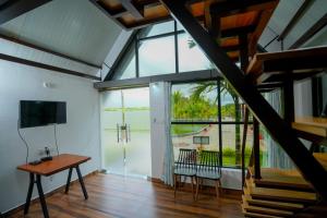 VastāraRG The Grand Haven Resort的一间有桌子、椅子和窗户的房间