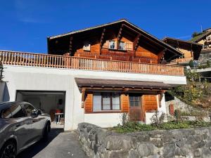 a house with a car parked in front of it at Charmantes Chalet mit Studio & Bergblick in Habkern