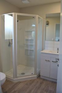 a bathroom with a shower and a toilet and a sink at Oxford Village Motels in Oxford