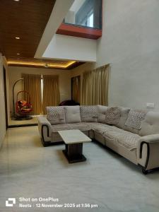 un soggiorno con un divano e un tavolo di BachavatS Villa Family Guest House a Kharakvasla