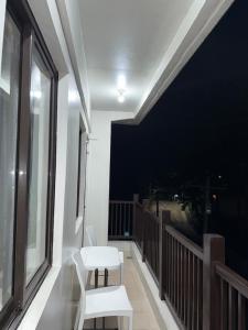 ein Balkon mit einer weißen Bank und einer schwarzen Wand in der Unterkunft Rent & Roam in Baguio City