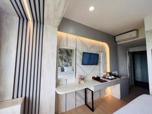 a bedroom with a desk and a bed in a room at The Belagri Hotel and Convention in Sorong