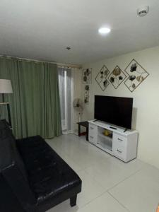 ein Wohnzimmer mit Fernseher und Sofa in der Unterkunft Rent & Roam in Baguio City