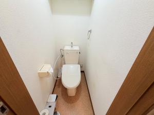 een badkamer met een wit toilet in een stal bij ハイツ清水102 in Nagasaki +9 foto's