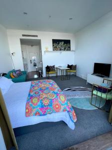 sypialnia z łóżkiem z kolorowym kocem w obiekcie Heritage studio with private balcony w Auckland