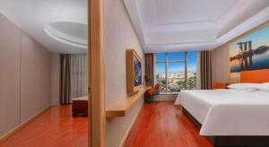 a hotel room with a bed and a large window at Vienna Hotel Shenzhen International Exhibition Center Fuhai Qiaotou in Fenghuangwei +112 photos